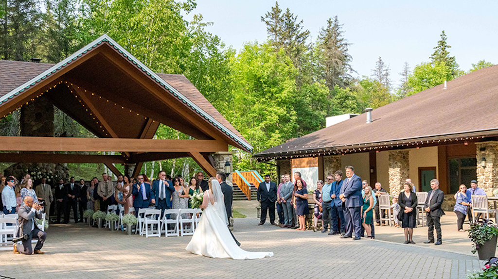 A bride is escorted to the wedding venue at the Yodeler Lodge on a sunny day. 